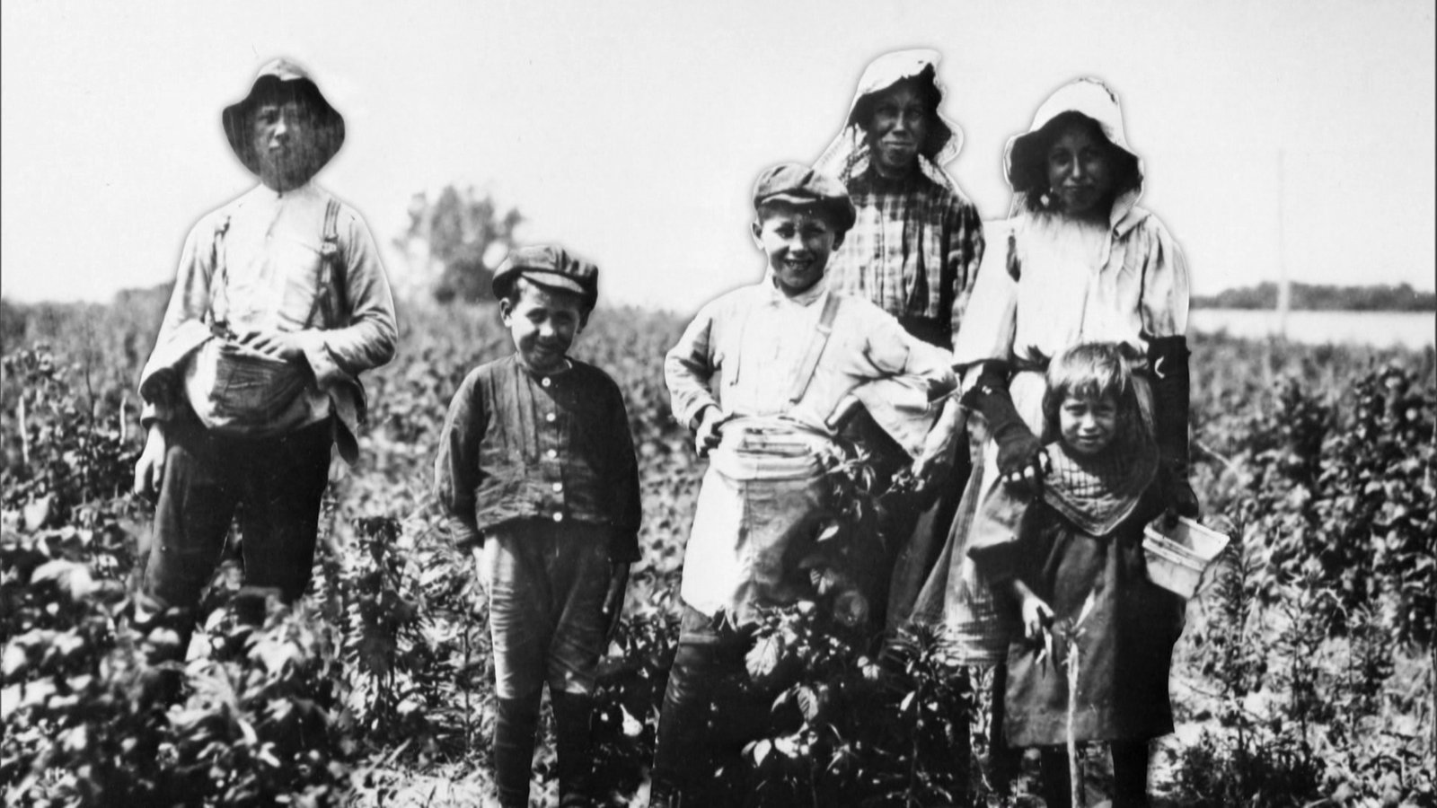 Schwarz-Weiß-Aufnahme einer Familie auf dem Feld