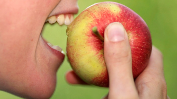 Frau beißt in Apfel