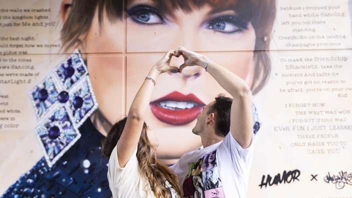 Zwei Fans vor einem Wandbild der US-Sängerin Taylor Swift