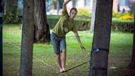 Mann balanciert auf Slackline