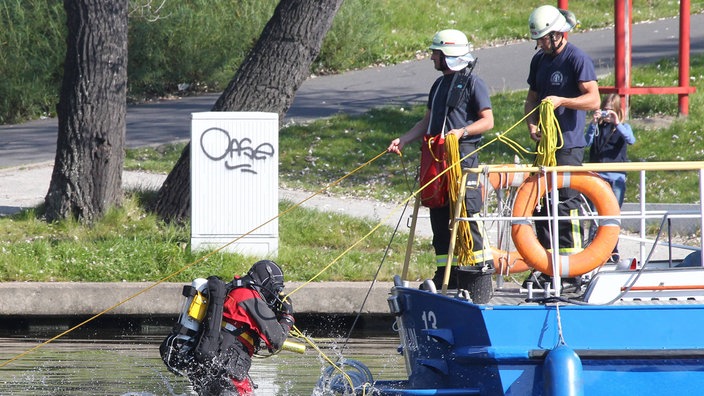 Einsatztaucher von Wasserschutzpolizei und Feuerwehr suchen nach einer vermissten Person.