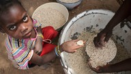 Ein kleines Maedchen kauft Hirse in Fada Ngourma (Burkina Faso).