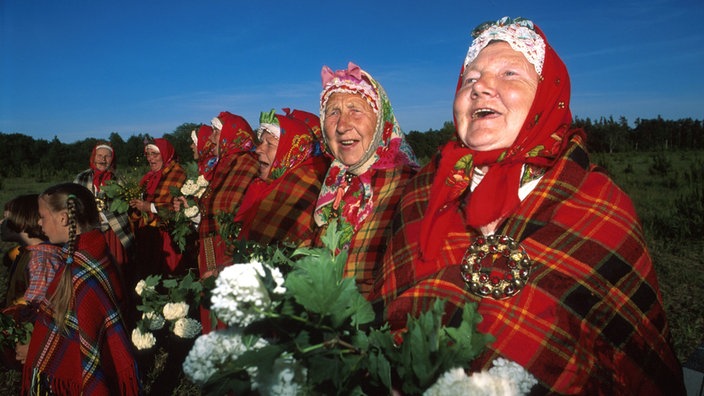 Frauen und Mädchen singen in regionaltypischer Tracht.