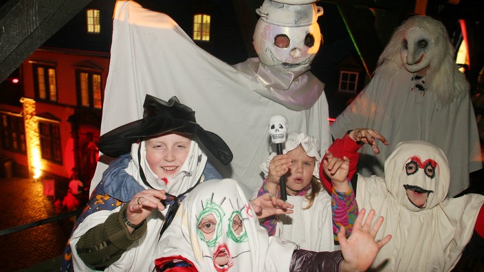 Als Geister verkleidete Familie an Halloween.