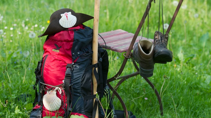 Rucksack, Hut mit Jakobsmuschel, Wanderschuhe und Pilgerstab 