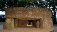 Frontalansicht eines Dolmens mit seitlichen Platten als Stütze und einer großen Deckplatte.