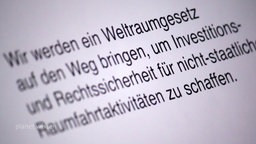 Monitor auf dem steht 'Wir werden ein Weltraumgesetz auf den Weg bringen, um Investitions- und Rechtssicherheit für nicht-staatliche Raumfahrtaktivitäten zu schaffen.'