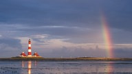 Der rotweiß gestreifte Leuchtturm Westerheversand in Schleswig-Holstein bei Ebbe