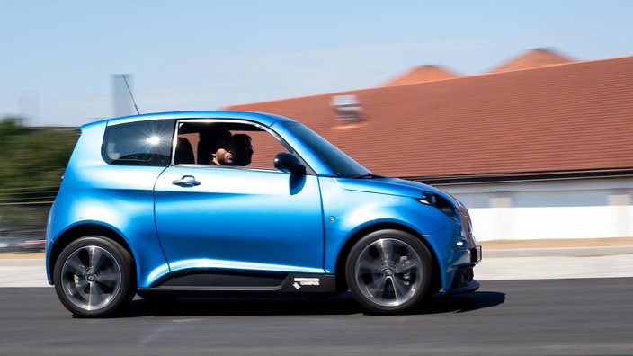 Ein blaues Elektroauto fährt auf einer Straße